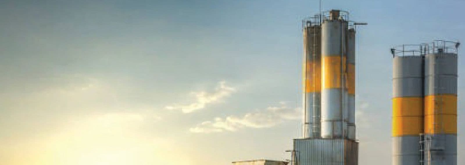 Cement plant silos at sunset